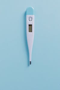 Minimalist digital thermometer on a pastel blue backdrop, ideal for medical themes.